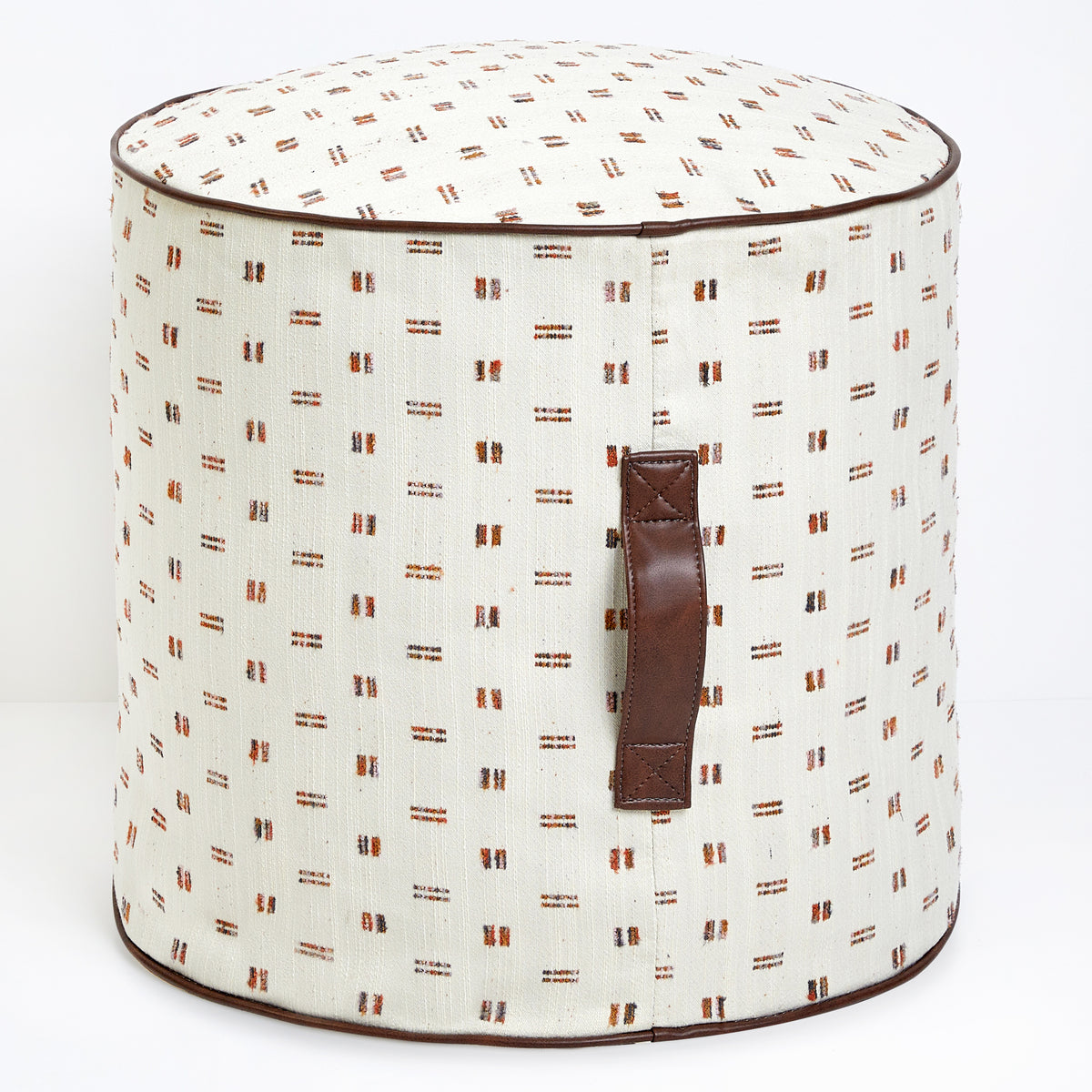 Round fabric ottoman or pouf with a patterned design in brown and cream, featuring a handle on the side.