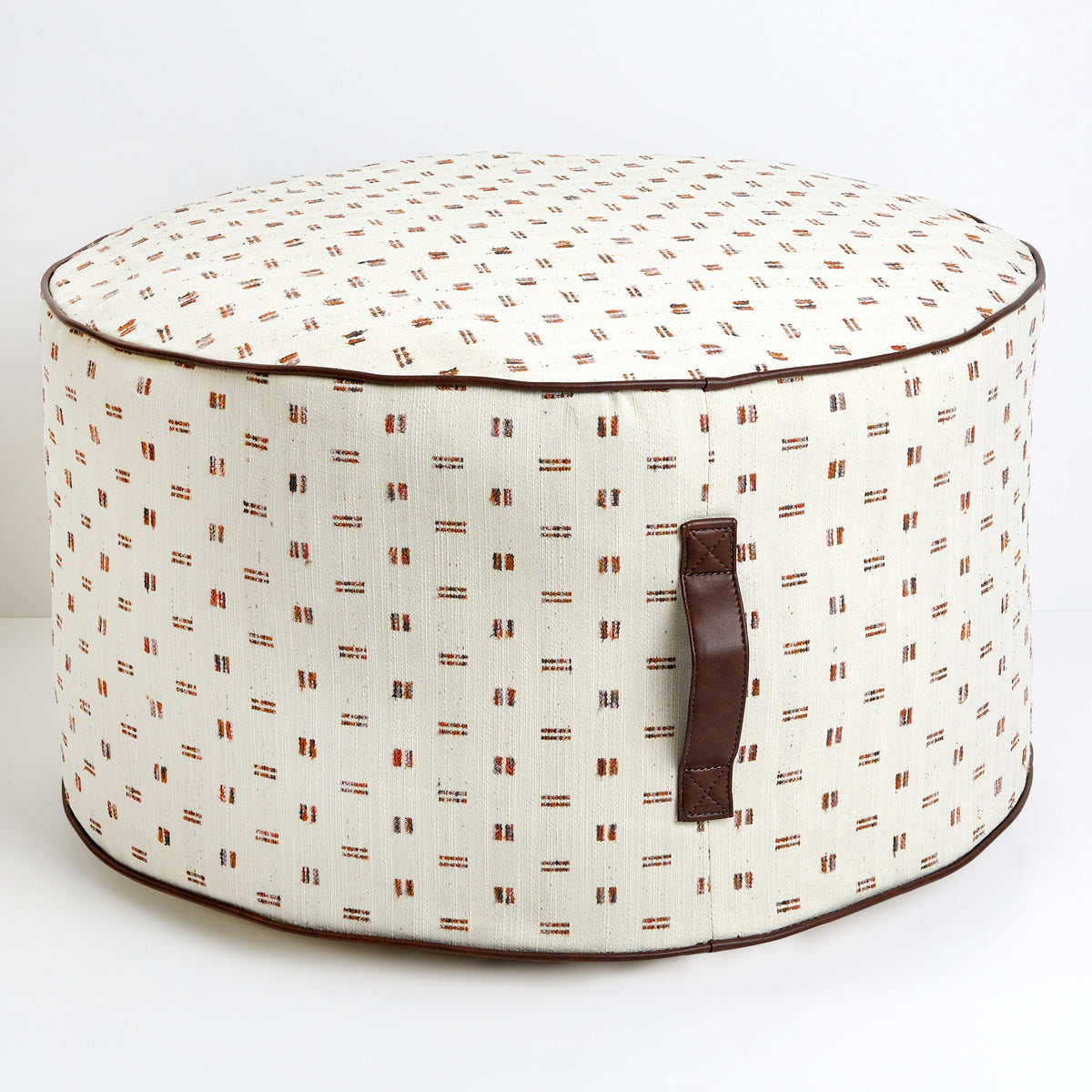 Round fabric ottoman or pouf with a blue patterned design and a handle on the side.